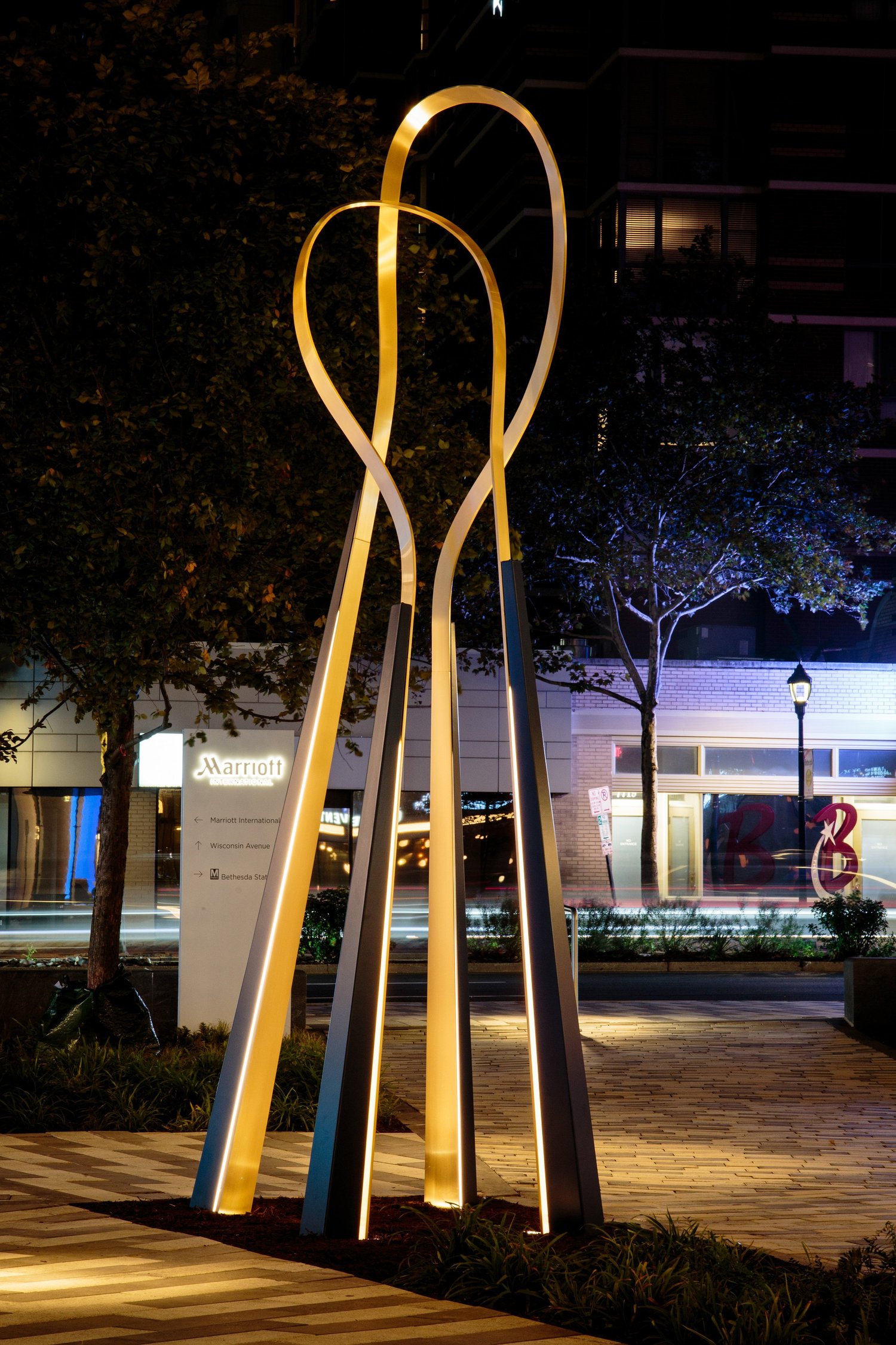 The Embrace illuminated in the courtyard after dark