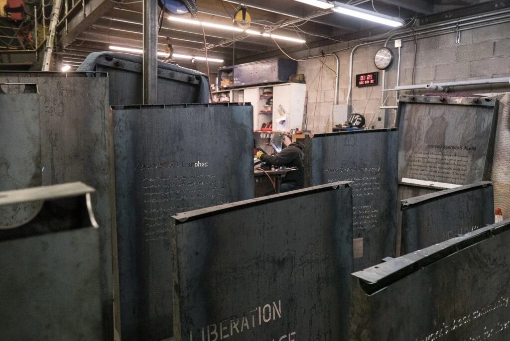 Formed learning-wall text panels standing at different heights in the fabrication shop