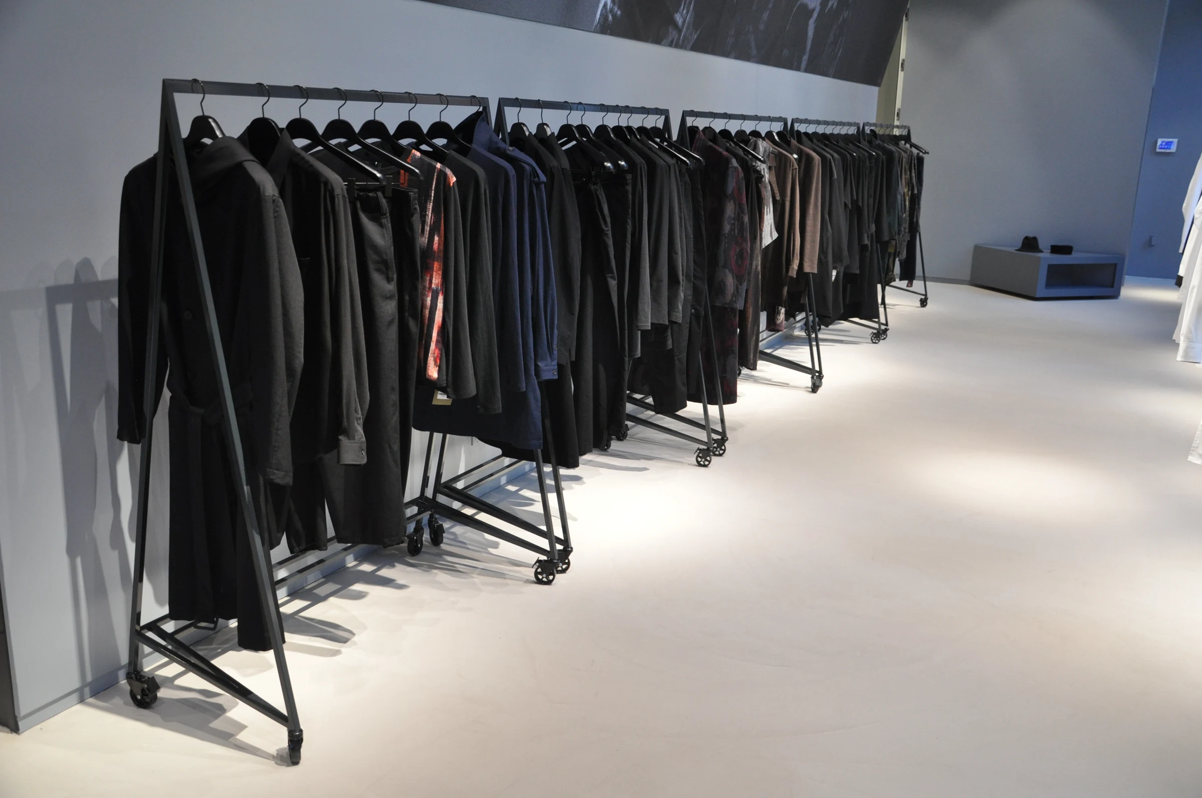 A row of finished steel racks with clothing in the retail space.